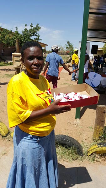 Teacher from Mbongo putting ribbons on people